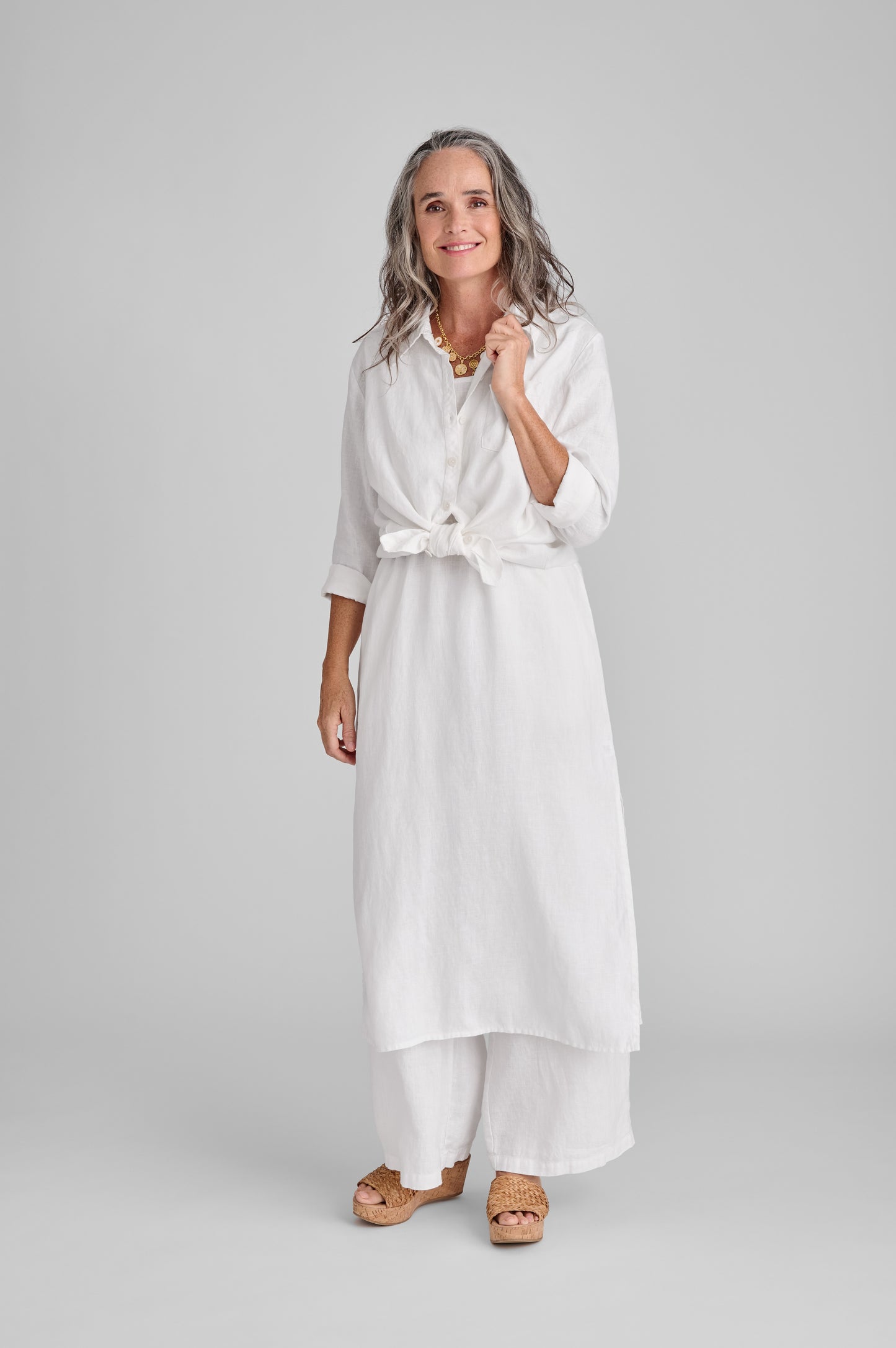 Bias Back Shirt (White) shown tied at waist, layered over the Slipster Dress (White), with the Flowing Pant (white).  Model is 5'9" wearing size Small. 100% European Linen.