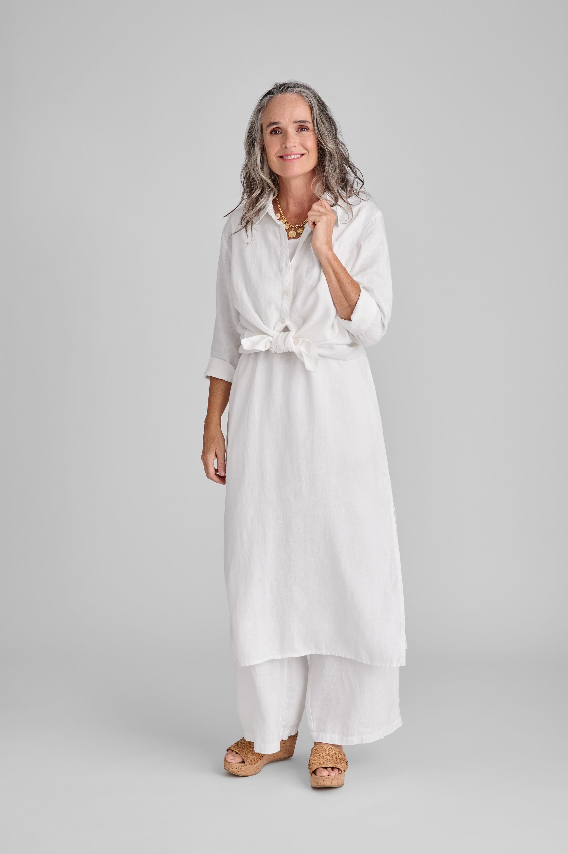 Bias Back Shirt (White) shown tied at waist, layered over the Slipster Dress (White), with the Flowing Pant (white).  Model is 5'9" wearing size Small. 100% European Linen.