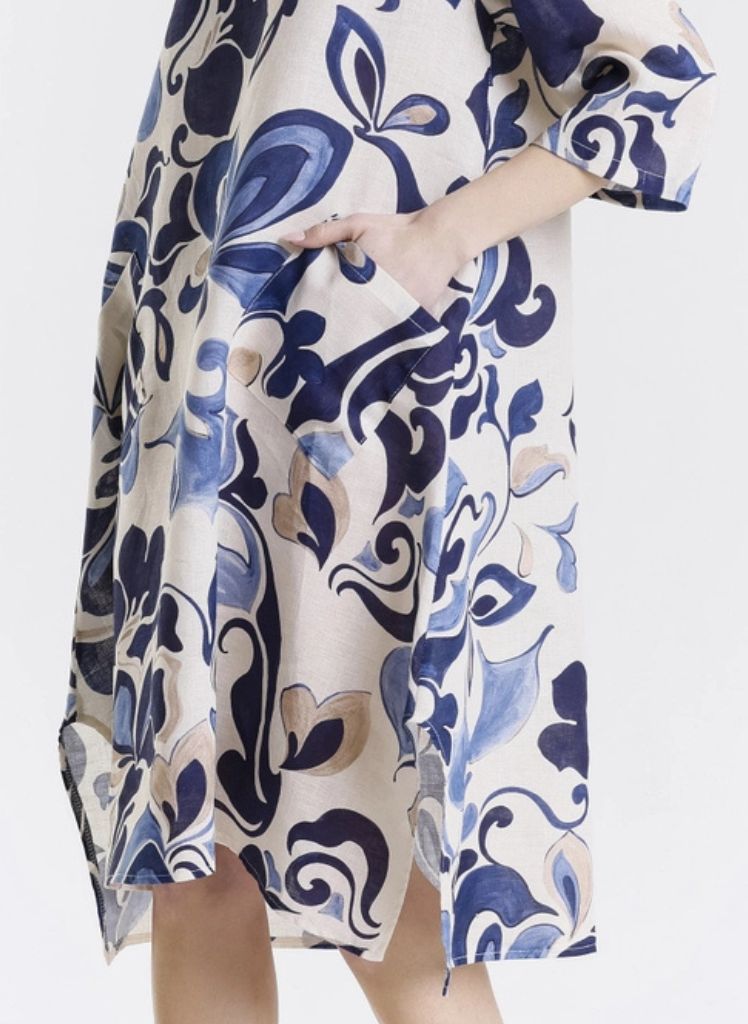 April Fleur Dress, shown in Navy, on the side.  Featuring asymmetric pocket and 3/4 sleeve, and hem slit detail. One size,  Model is approximately 5'9" tall.  100% Linen, Made in Italy.