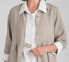 Button Down Dress (duster), shown in Natural.  Worn open, as a Duster jacket layered over the Bias Back Shirt, White.  Zoomed in on the waist defined by the  horizontal seams, and button tab detail.  