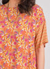 Daisy Top, shown in Peach.  features contrasting smaller print on the sleeve.