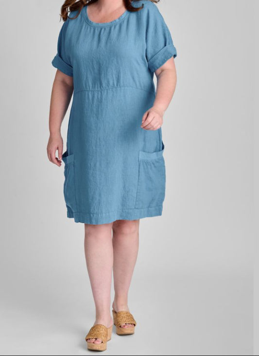 Sunny Side Dress, shown in Caribbean, size Medium. A knee length dress, with empire waist detail, and elbow length short sleeves (shown rolled up). 100% Linen (Body) with Cotton Knit Trim along the round neckline and the top edge of the 2 large patch pockets. Model is 5'9" tall.