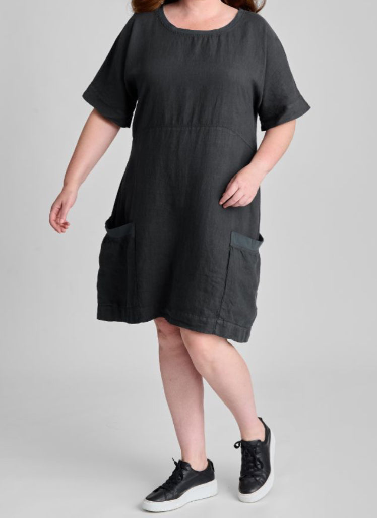 Sunny Side Dress, shown in Faded Black, size Medium. A knee length dress, with empire waist detail, and elbow length short sleeves (that can easily be rolled up). 100% Linen (Body) with Cotton Knit Trim along the round neckline and the top edge of the 2 large patch pockets. Model is 5'9" tall.