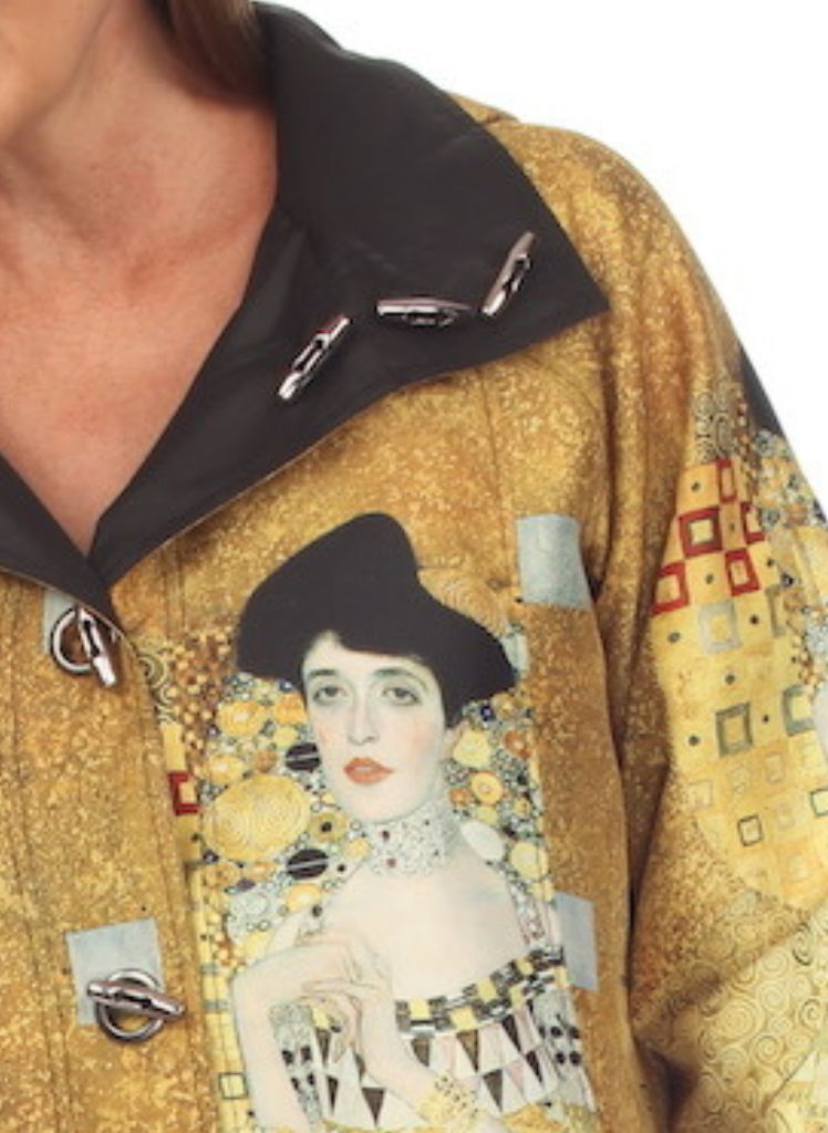 Woman in Gold Rain Coat, zoomed to feature the shawl collar, toggle button closure, and the pattern/colors.