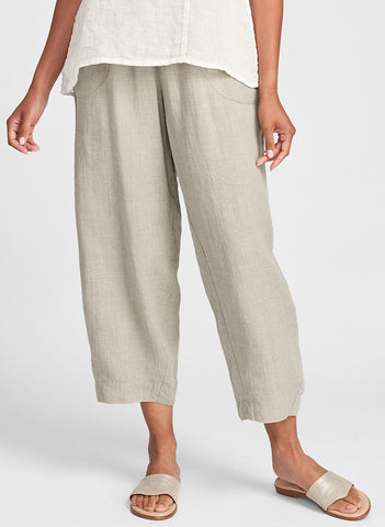 Seamly Pant (shown in Natural), ankle length linen pant with a full elastic waist, side pockets, and roomy legs that taper along the gathered cuff.